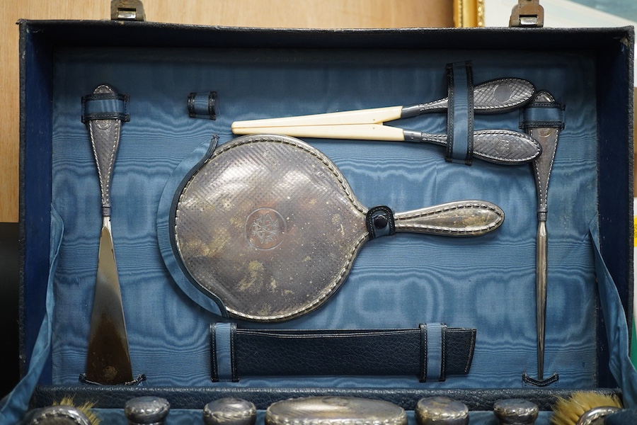 Two fitted travelling vanity cases, one with eight silver mounted toilet jars etc. by Asprey & Co, London, 1938, the other with seventeen silver mounted items, Thomas Jones Watson, London, 1911(incomplete).